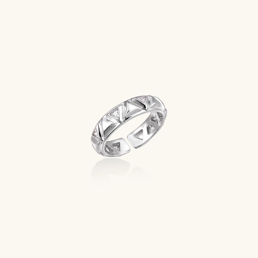 White gold adjustable ring with geometric triangle cutouts and zirconia stones on cream background