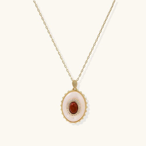 Gold pendant with oval mother-of-pearl frame, amber stone center, and crystal halo on delicate chain